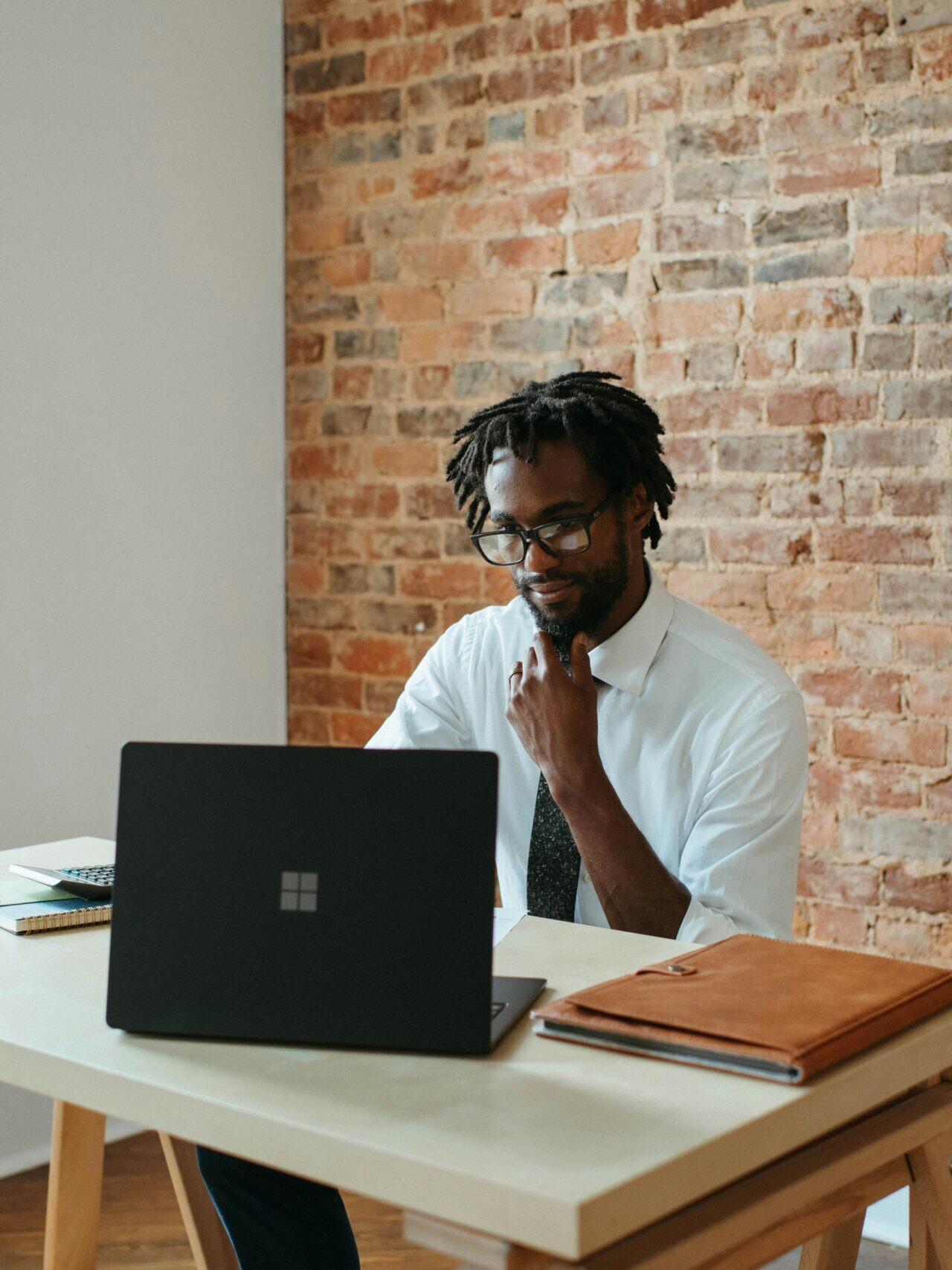 a man sitting at a table in front of a laptop