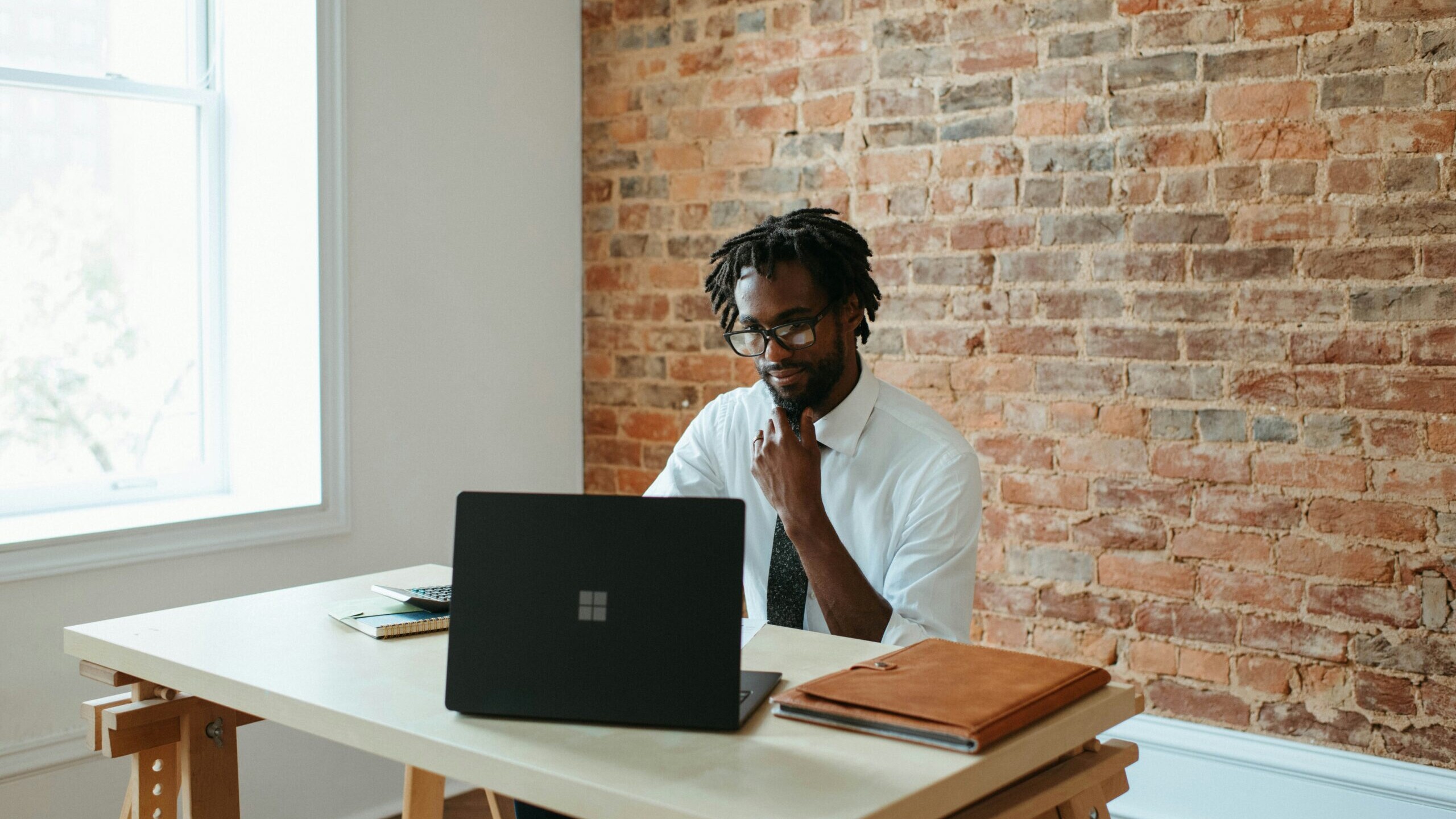 a man sitting at a table in front of a laptop