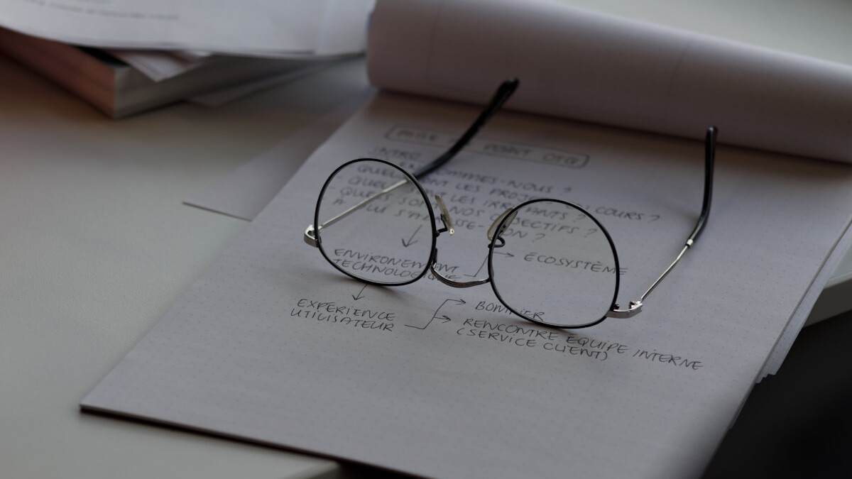 black framed eyeglasses on top of white printing paper