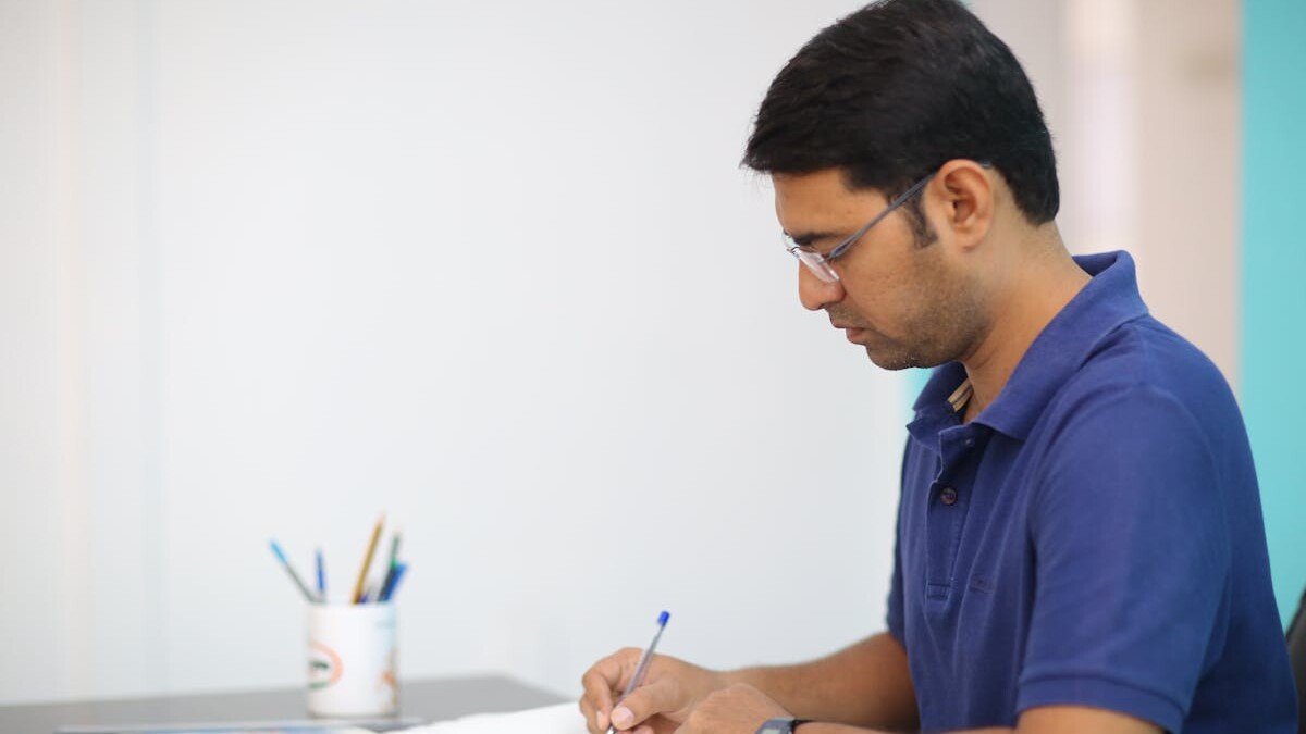 Man in Blue Polo Shirt Writing