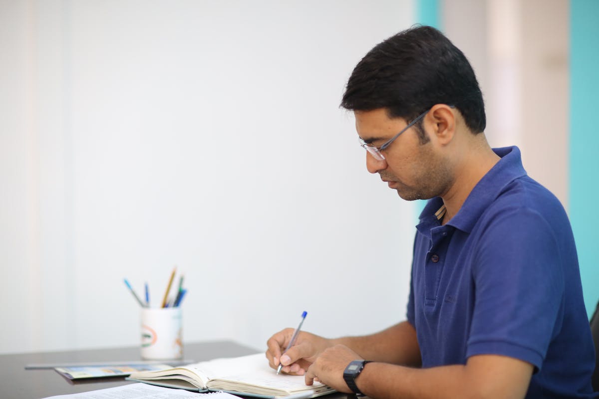 Man in Blue Polo Shirt Writing