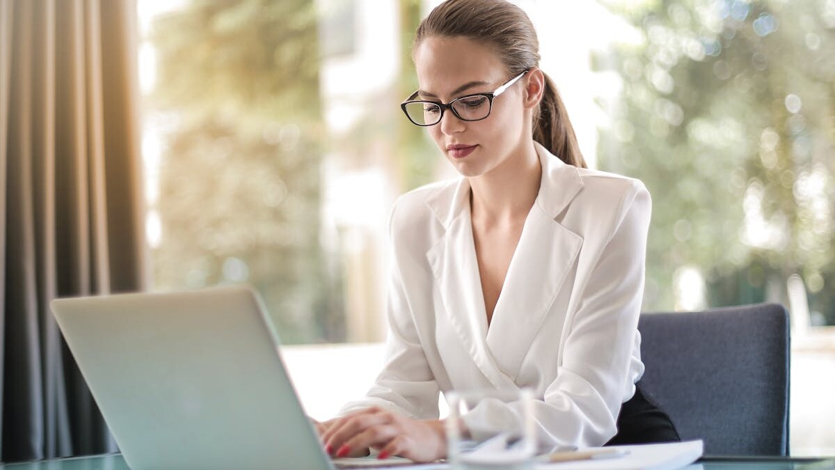 Concentrated female entrepreneur typing on laptop in workplace