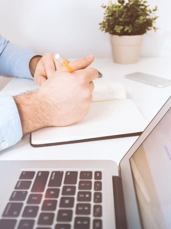 Person Holding Pen and Notebook