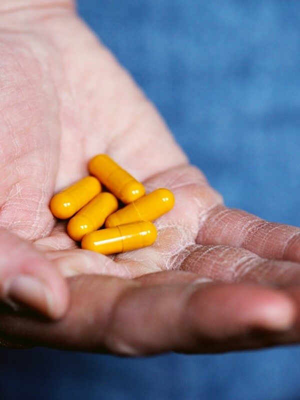 yellow medication pill on persons hand