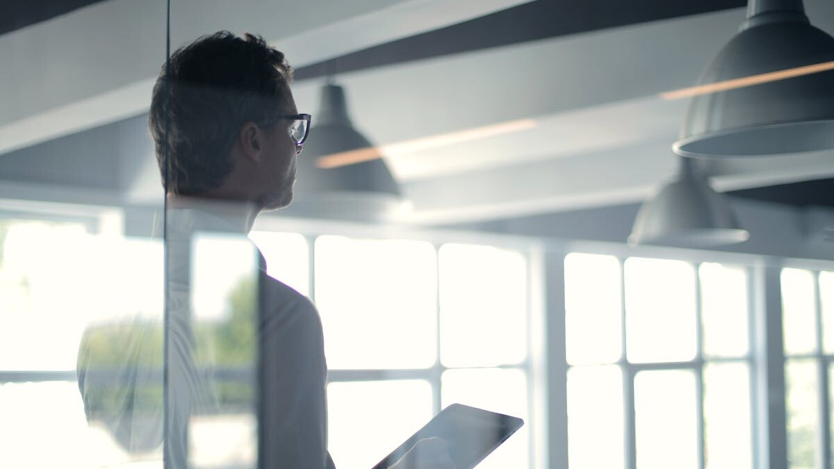 Formal man with tablet giving presentation in office