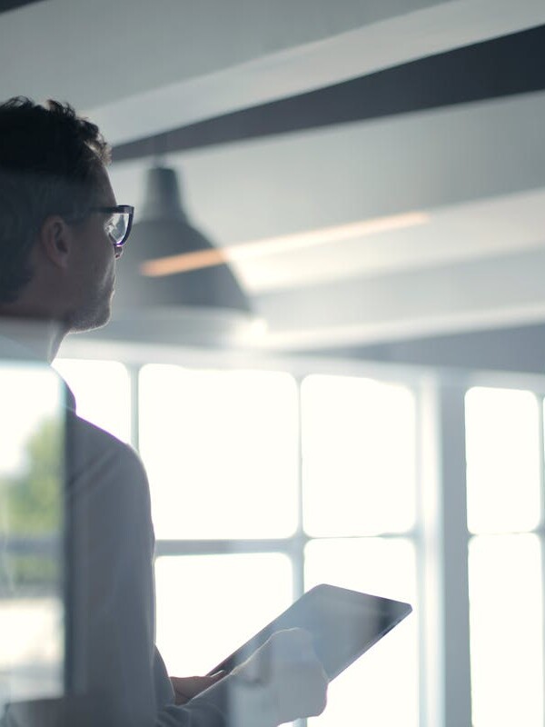 Formal man with tablet giving presentation in office