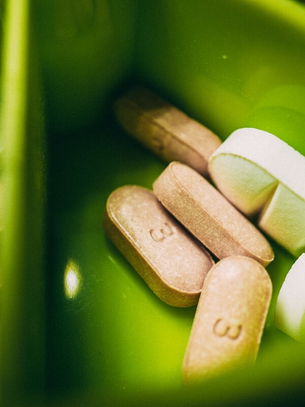 white medication pill on green plastic container