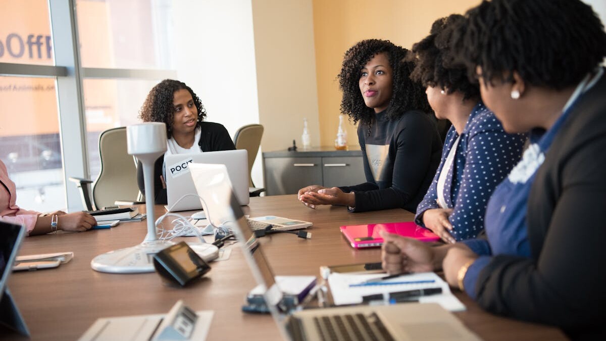 Diverse team of professionals engaging in a collaborative office meeting around a desk.