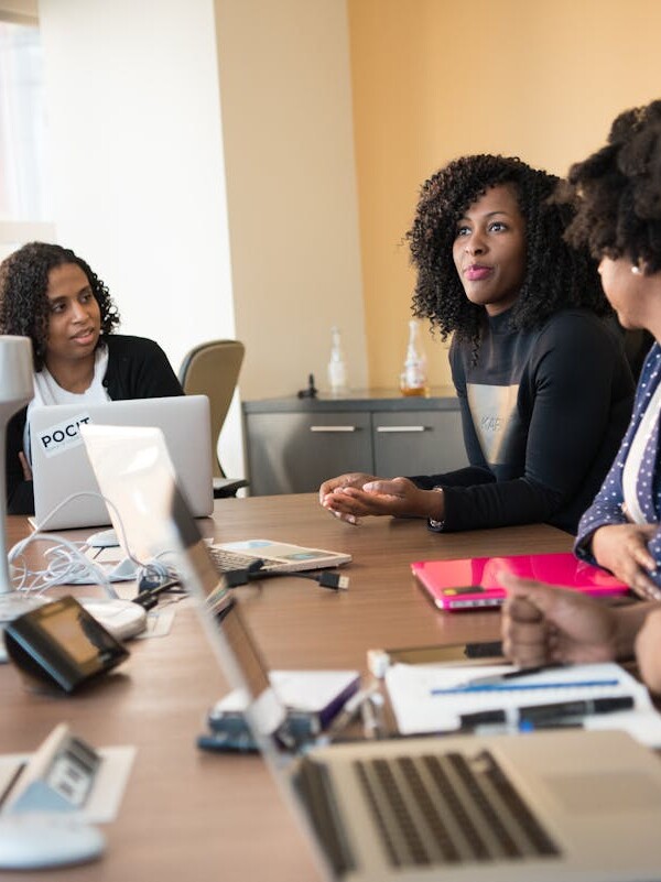 Diverse team of professionals engaging in a collaborative office meeting around a desk.