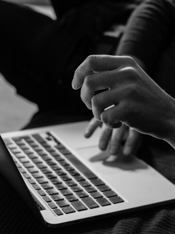 grayscale photo of person using MacBook