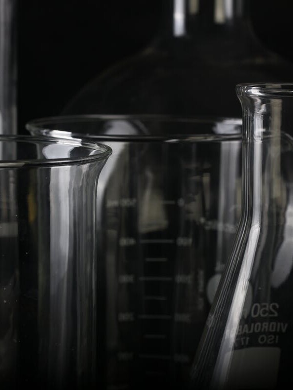 A detailed close-up of various transparent laboratory glassware used in scientific experiments.