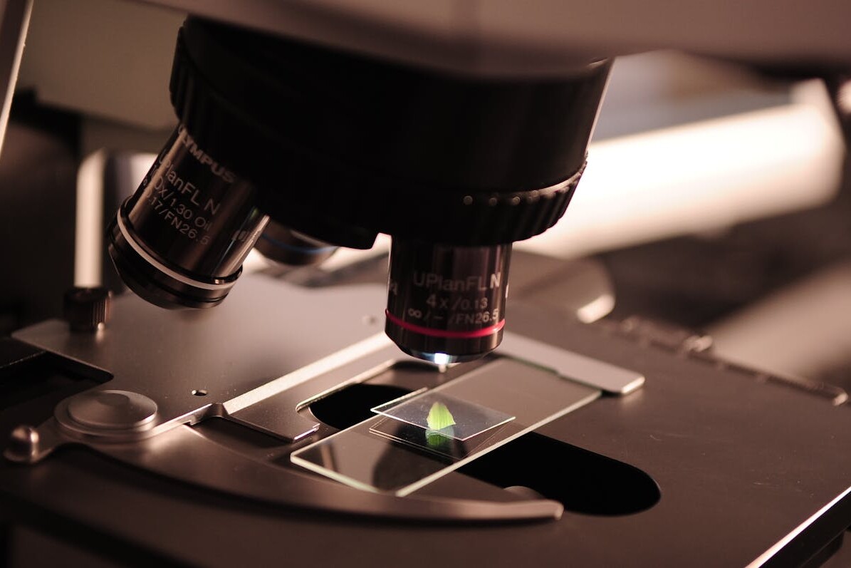 Detailed view of a microscope with a slide in a laboratory environment.