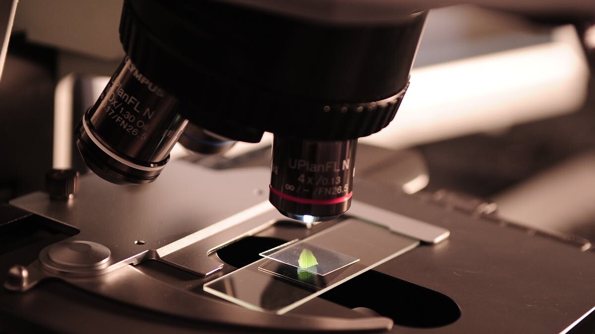 Detailed view of a microscope with a slide in a laboratory environment.