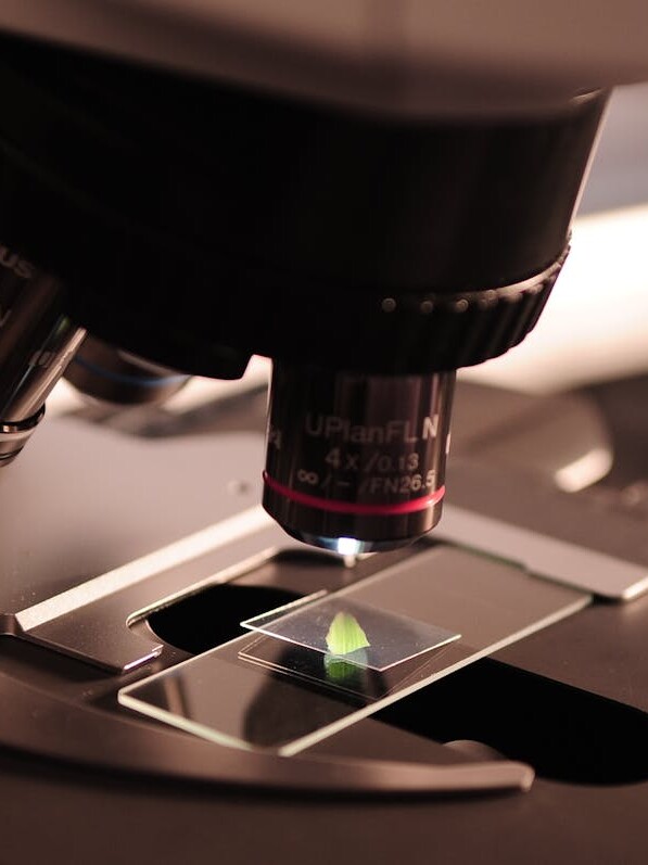 Detailed view of a microscope with a slide in a laboratory environment.