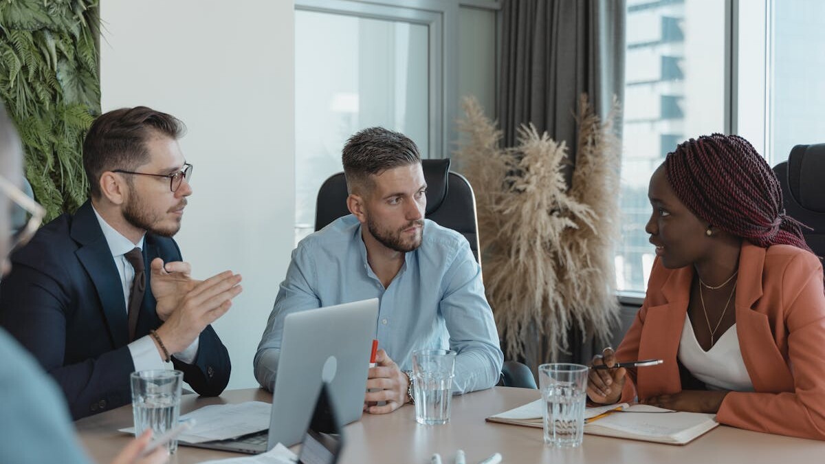 A group of professionals engaging in a collaborative discussion in a modern office setting.