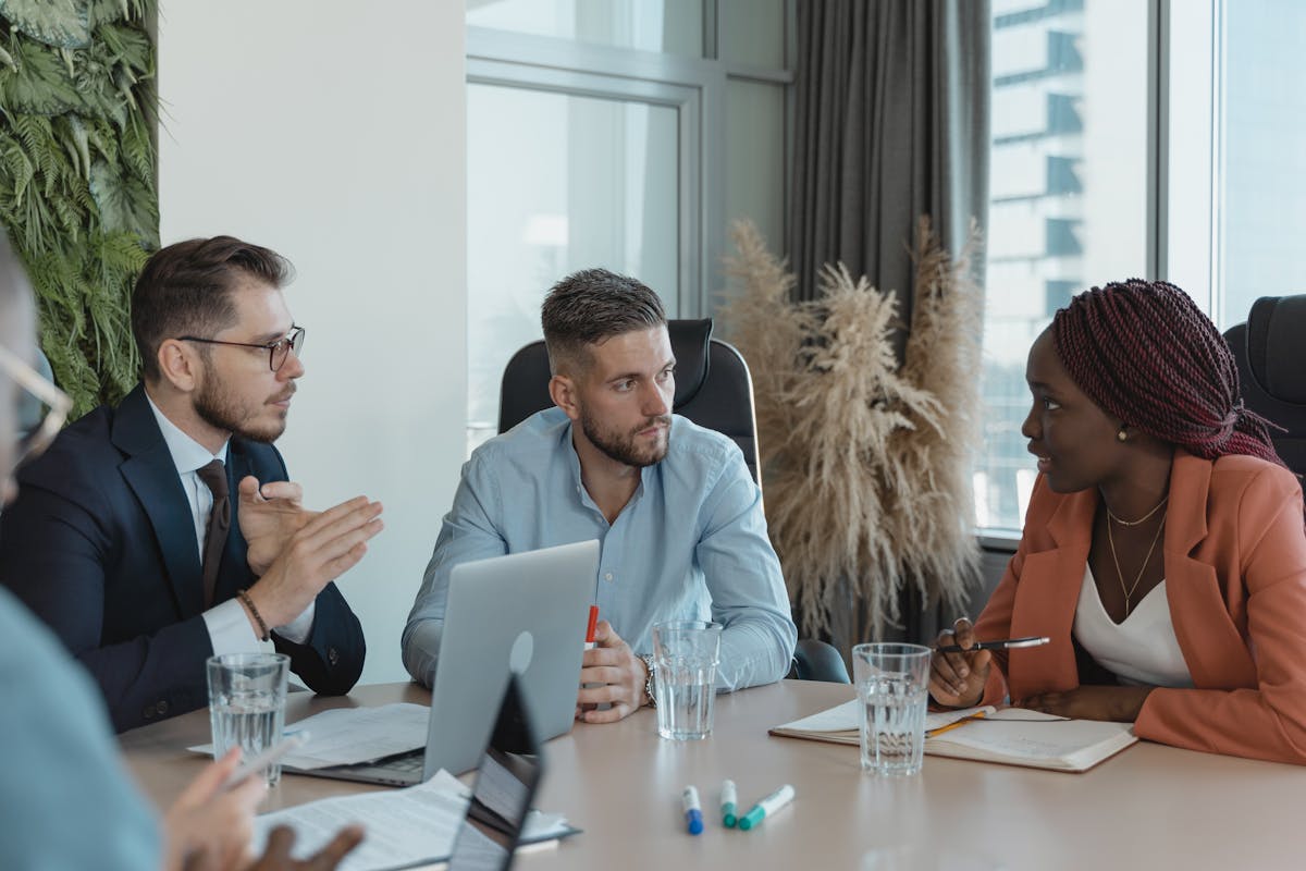 A group of professionals engaging in a collaborative discussion in a modern office setting.