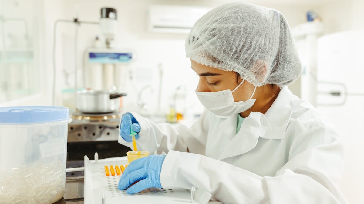 A scientist wearing protective gear performs a meticulous experiment in a laboratory setting.