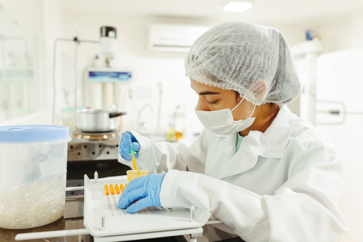 A scientist wearing protective gear performs a meticulous experiment in a laboratory setting.