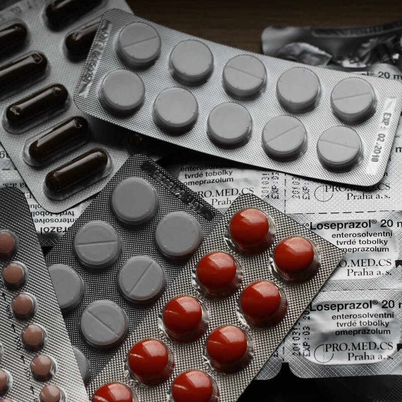 Close-up of various pills in blister packs showcasing medical and healthcare themes.